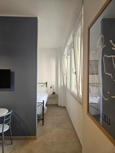 ein kleines Zimmer mit einem Bett und einem Tisch und einem Schlafzimmer in der Unterkunft host19 in Campobasso