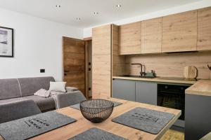 a kitchen and living room with a table and a couch at Alp Tirol Home in Pellizzano
