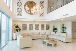 a living room with a white couch and a chandelier at Hotel Tayrona del Mar in Santa Marta