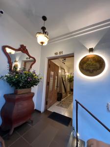 a hallway with a mirror and a vase with flowers at Leclerc Hotel Boutique Cali Granada in Cali