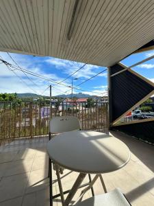 a white table and a chair on a balcony at Tamaly's Lodges in Basse-Terre