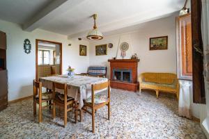a dining room with a table and a fireplace at Balocco Countryside Home 1908 - Barga in Sommocolonia +17 photos