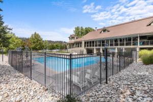 a fence in front of a house with a pool at The Fairway To Heaven in Rathdrum