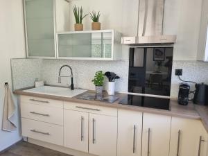 a kitchen with white cabinets and a sink at La Maison des Muses in Arles +27 photos