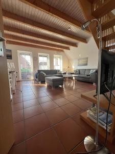a large living room with couches and a tv at SörenHuus Neßmersiel in Dornum