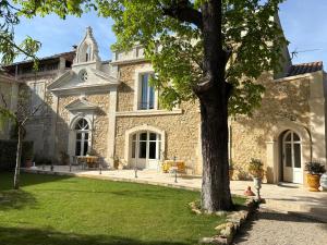 a large stone building with a tree in the yard at La Chapelle in Orange