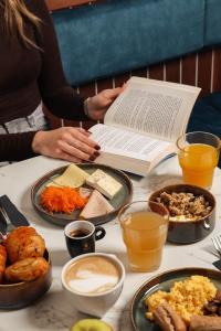 a table topped with plates of food and a book at BX Downtown - Brussels in Brussels