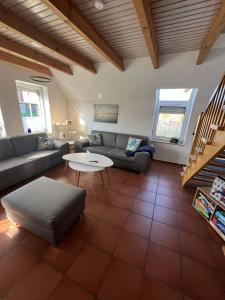 a living room with a couch and a table at SörenHuus Neßmersiel in Dornum