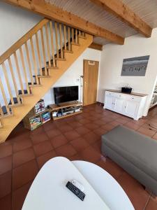 a living room with a couch and a staircase at SörenHuus Neßmersiel in Dornum +28 photos