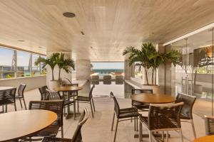 a restaurant with tables and chairs and a view of the ocean at Venti Hotel - By Brisa Hotéis - Soft Opening in Maceió