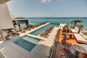 a hotel with a pool and chairs and the ocean at Venti Hotel - By Brisa Hotéis - Soft Opening in Maceió