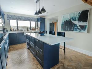 a kitchen with blue cabinets and a white counter top at Pengarnedd in Amlwch