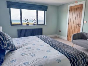 a bedroom with a bed with a view of the ocean at Pengarnedd in Amlwch