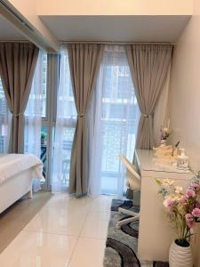 a bedroom with a bed and a desk and windows at Parksuites Tower 2 in Manila +51 photos