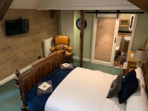 a bedroom with a large bed and a chair at The Kings Arms Pub in Stratton on the Fosse