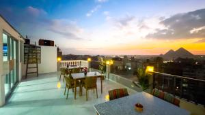 a balcony with a table and chairs and a sunset at NEW ASSER HOTEL PYRAMID in Cairo