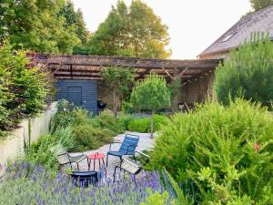 a patio with chairs and tables in a garden at Encore une fois, La grande maison in Locmalo