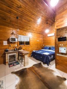 a bedroom with a bed and a desk and a fireplace at Cabanas Sitio Amigos in Bento Gonçalves