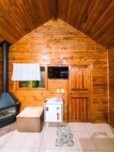 a room with a stove in a wooden room at Cabanas Sitio Amigos in Bento Gonçalves