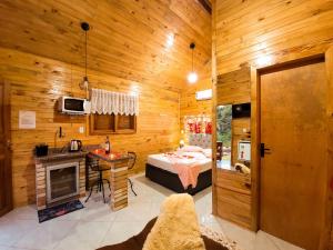 a bedroom with a bed and a desk and a fireplace at Cabanas Sitio Amigos in Bento Gonçalves