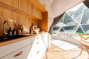 a kitchen with white cabinets and a large window at 53 North in Bodham