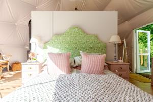 a bedroom with a large bed with pink pillows at 53 North in Bodham