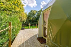 a large green tent with a wooden deck at 53 North in Bodham +13 photos