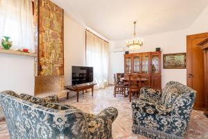 a living room with chairs and a tv and a table at Villa dei Domenicani in Copertino