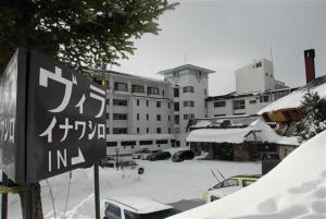 a sign in the snow in front of a building at Villa Inawashiro in Inawashiro