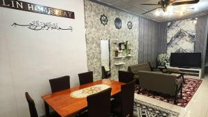 a dining room with a table and chairs and a television at Lin Homestay in Lahad Datu