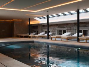 ein Schwimmbad in einem Hotel mit Liegestühlen in der Unterkunft Hotel Verviers Van der Valk in Verviers