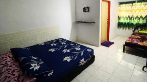 a bedroom with a blue bed with flowers on it at Lin Homestay in Lahad Datu +1 photo