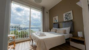 a bedroom with a bed and a large window at Sea Balcony House in Senglea