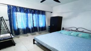 a bedroom with a bed and a large window at Lin Homestay in Lahad Datu