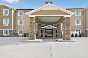 a large building with two pillars in front of it at Cobblestone Hotel & Suites - Eaton in Eaton