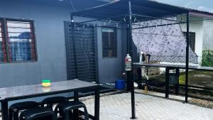 a patio with a table and chairs and an umbrella at Lin Homestay in Lahad Datu