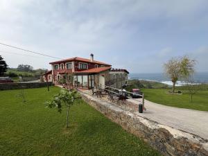 a house on a hill next to the ocean at Posada Punta Liñera in San Vicente de la Barquera