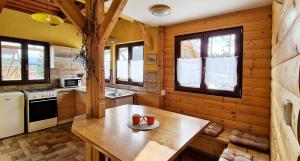 a kitchen with wooden walls and a table with two mugs on it at Chata Sandra in Lipno nad Vltavou