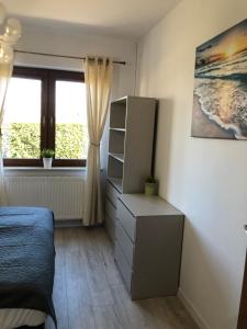 a bedroom with a bed and a dresser and a window at AsPa in Ostrowo