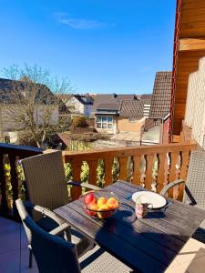 a wooden table with a bowl of fruit on a balcony at KM APPARTS Wesel 6 in Wesel