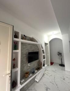a living room with a stone fireplace with a tv at Shtepi Pushimi in Mezhgoran