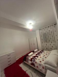 a bedroom with a bed and a red rug at Shtepi Pushimi in Mezhgoran