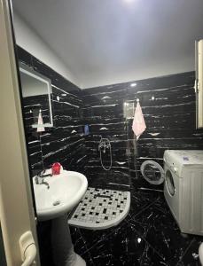 a black bathroom with a sink and a toilet at Shtepi Pushimi in Mezhgoran