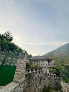 a house on a hill with a green gate at Shtepi Pushimi in Mezhgoran +4 photos