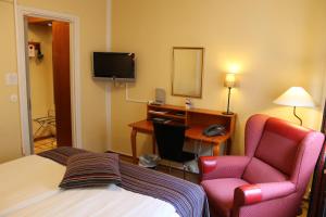 a hotel room with a bed and two chairs and a desk at Teaterhotellet in Malmö