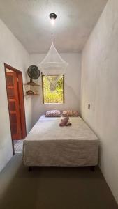 a bedroom with a bed and a window at Taboca Chalé na Rua do Serrão in Cairu