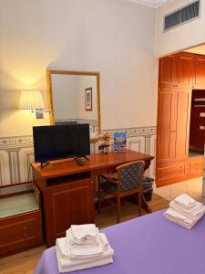 a bedroom with a desk with a computer and a mirror at City Hall in Catania
