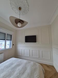 a bedroom with a bed and a flat screen tv at Appartement duplex Granville in Granville