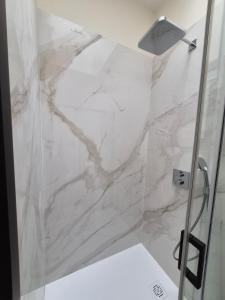 a bathroom with a marble shower with a shower curtain at Appartement duplex Granville in Granville