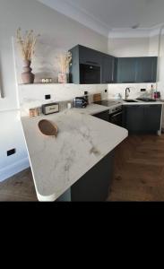 a large kitchen with a marble counter top at Appartement duplex Granville in Granville